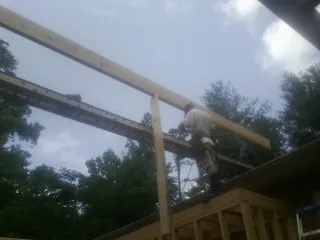 Carpenter setting a ridge beam over a new addition frame — Ice Dam Removal by Roofing Brothers in Epworth