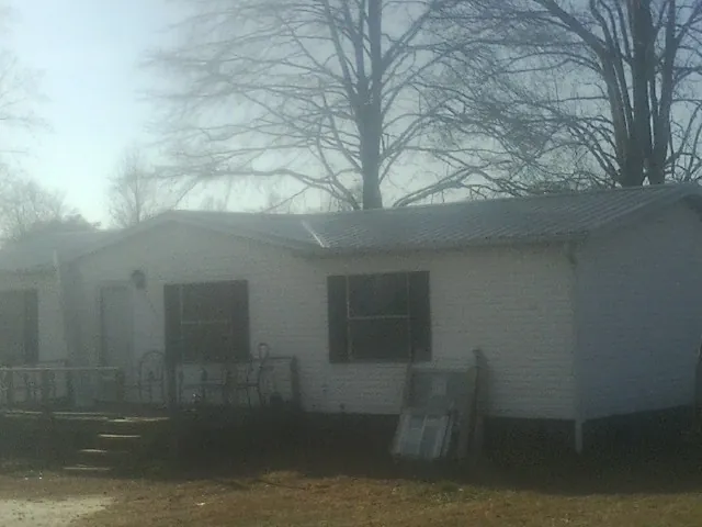 New metal roof on a white painted brick home on a foggy morning in Epworth