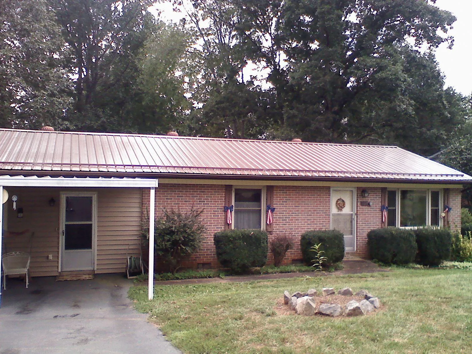 Bronze metal roof and carport on a brick ranch home — Roof Repair work by our crew in Epworth
